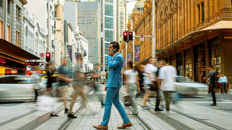 A business traveller crossing a street in central Sydney.